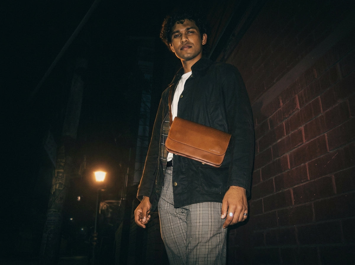 On a Dhaka alley at night — leather crossbody catching streetlamp warmth